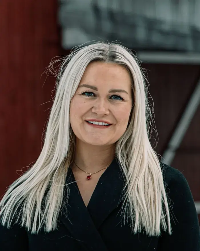 Liv-Astrid Rustgaard Bjerke foran en rød låve