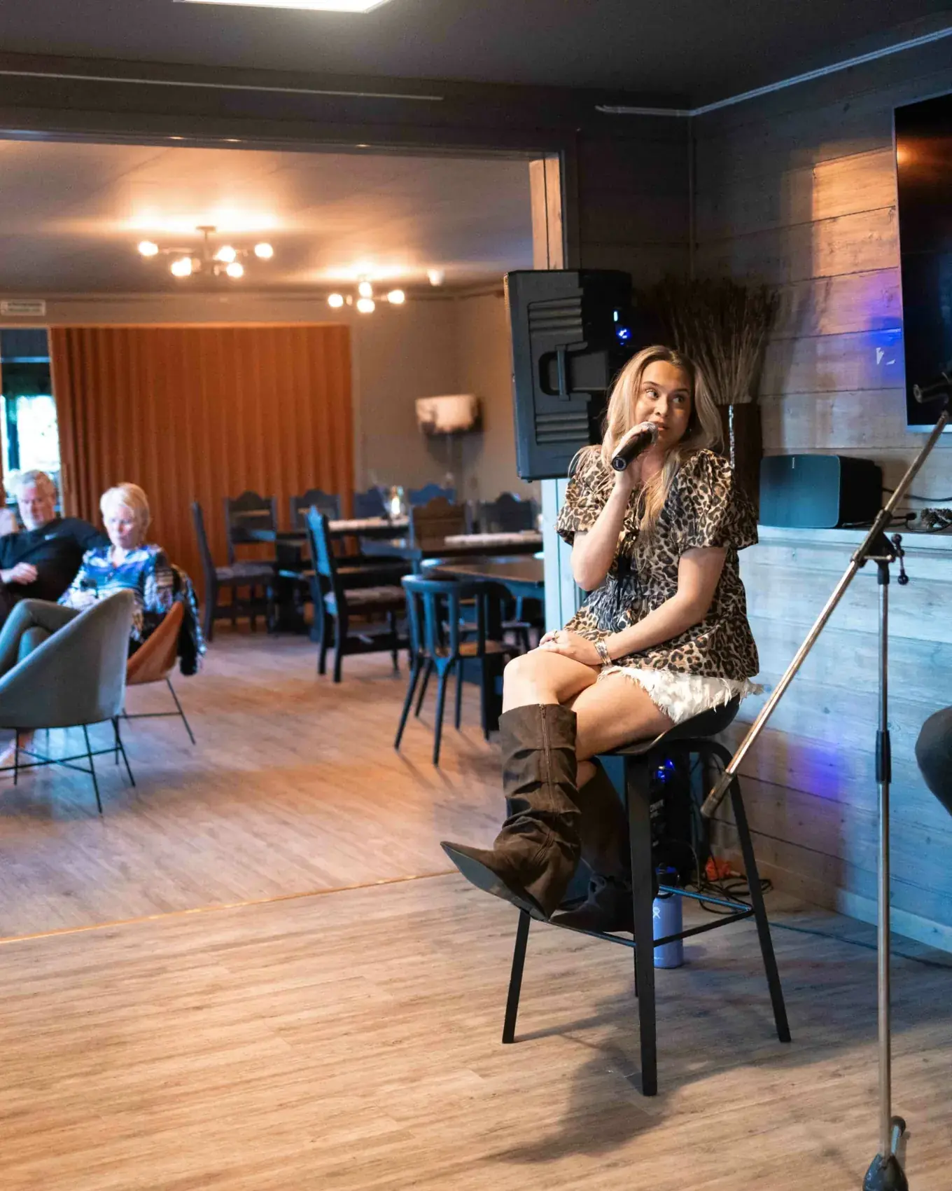 En kvinne synger for publikum i en kafé